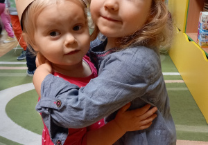 Dwie dziewczynki przytulają się.
