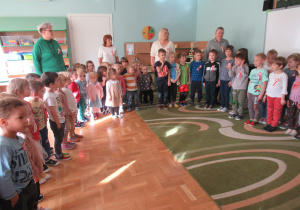 Dzieci stoją i śpiewają: "Hymn Polski".