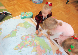 Dziewczynki pokazują na mapie Finlandie.