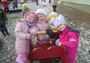 Dziewczynki pozują do zdjęcia na placu zabaw.