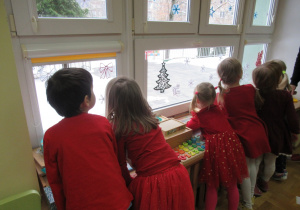 Dzieci wypatrują przez okno Świętego Mikołaja.
