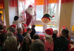 Mikołaj wchodzi do sali przez okno.