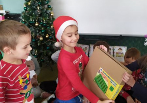Dzieci rozpakowują prezenty od Świętego Mikołaja