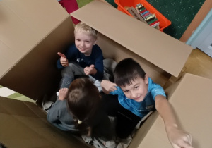 Dzieci siedzą w kartonie