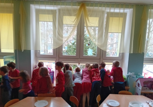 Dzieci wypatrują przez okno Świętego Mikołaja