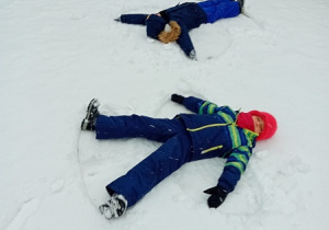 Dzieci leżą na śniegu