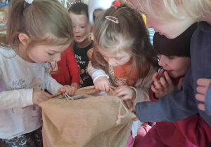 Dzieci otwierają worek z prezentami