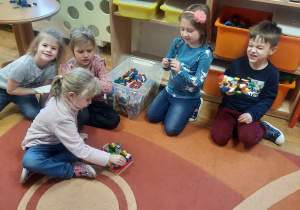 dzieci podczas zabaw w sali budują z klocków lego