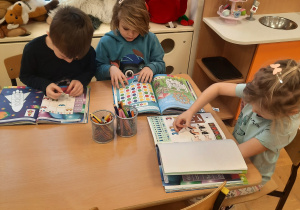 dzieci podczas zajęć dydaktycznych wykonują pracę w książce
