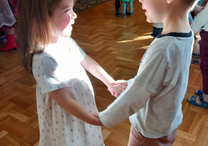 Chłopiec i dziewczynka trzymają się za ręce.