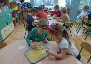 Dzieci bawią się w paleontologów szukając kości dinozaurów
