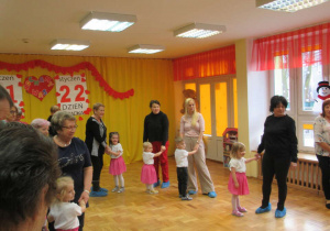 Przedszkolaki tańczą z babciami i dziadkami.