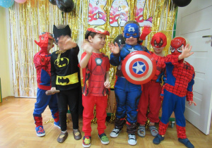 Chłopcy w strojach superbohaterów pozują do zdjęcia.