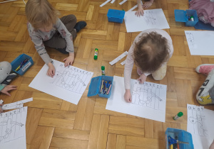 Dzieci układają puzzle a potem naklejają na kartce