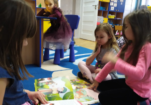 Dziewczynki podczas oglądania książek na dywanie
