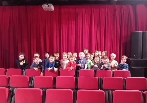 Dzieci stoją przed sceną teatralną