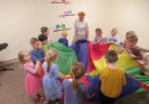 Dzieci trzymają chustę animacyjną podczas zajęć z rytmiki.