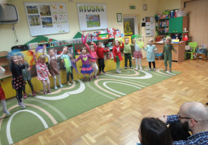 Dzieci tańczą z kolorowymi chusteczkami.