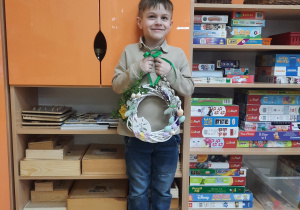 Chłopiec prezentuje wianek wykonany na warsztatach