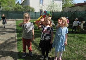 Dzieci pozują do zdjęcia podczas pobytu w ogródku przedszkolnym.