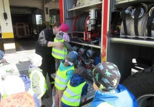Dzieci obserwują co jest w wozie strażackim.