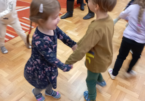 Chłopiec i dziewczynka tańczą.