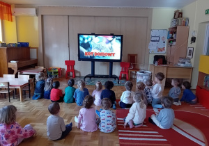 Dzieci oglądają film edukacyjny o kotach