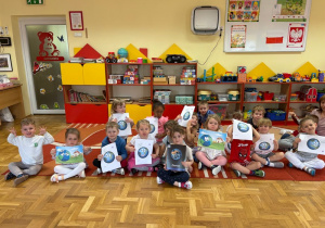 Dzieci trzymają obrazki przedstawiające Ziemię