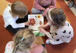 Dzieci oglądają książkę o roślinach