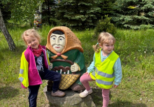 Dziewczynki pozują obok rzeźby