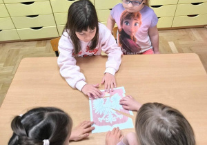 Dziewczynki podczas zajęć układają obrazek z części