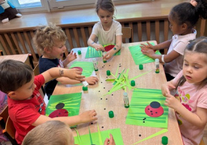Dzieci wykonują pracę plastyczną - "Biedronka" - z kół origami