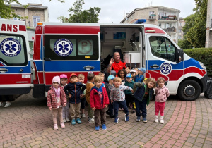 Dzieci stoją przed ambulansem