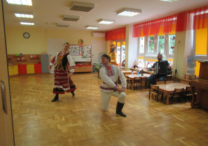 Pan i pani przebrani w stroje ludowe tańczą.