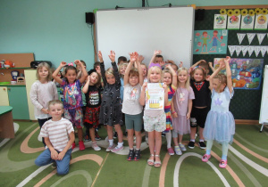 Dzieci pozują do zdjęcia podczas świętowania urodzin dziewczynki.