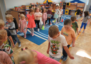 Dzieci przechodzą po naklejonej na podłodze linii z taśmy.