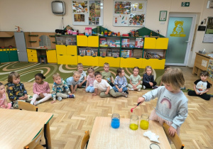 Dziewczynka miesza w słoikach kolorowe farby