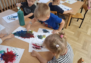 Dzieci w trakcie malowania farbami