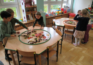 Dzieci układają kompozycje z darów jesieni.