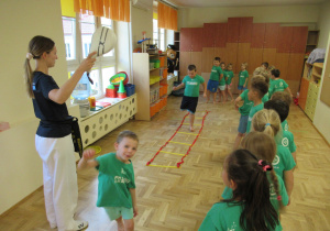 Dzieci ćwiczą na zajęciach gimnastycznych z elementami teakwondo.