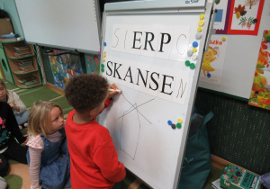 Chłopiec rysuje na tablicy.