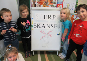 Dzieci stoją obok tablicy z napisem "Sierpc skansen".