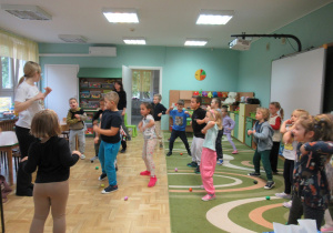 Dzieci stoją w rozsypce w sali podczas zajęć Roar Dance.