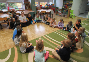 Dzieci siedzą w kole podczas zajęć Roar Dance.