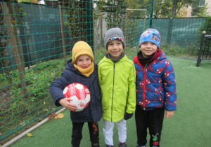 Chłopcy pozują do zdjęcia na boisku przedszkolnym.