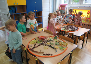 Dzieci oglądają swoje kompozycje z darów jesieni.