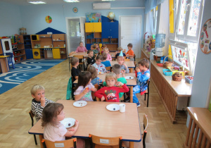 Dzieci siedzą przy stoliku podczas urodzinowego drugiego śniadania.