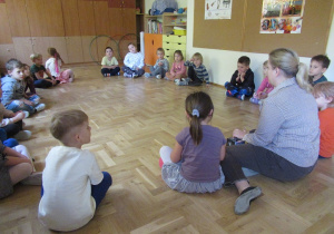 Dzieci siedzą w kole podczas rytmiki.