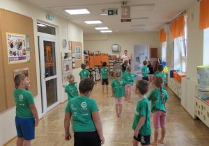 Dzieci stoją w rozsypce podczas zajęć z elementami teakwondo.