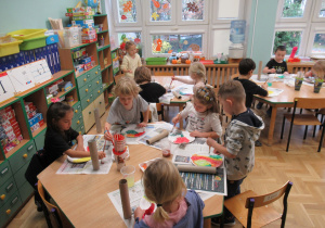 Dzieci malują farbami papierowe talerzyki.